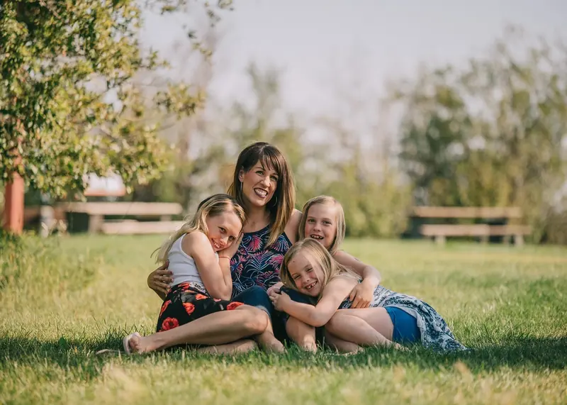 A mother and children relaxing together on the grass