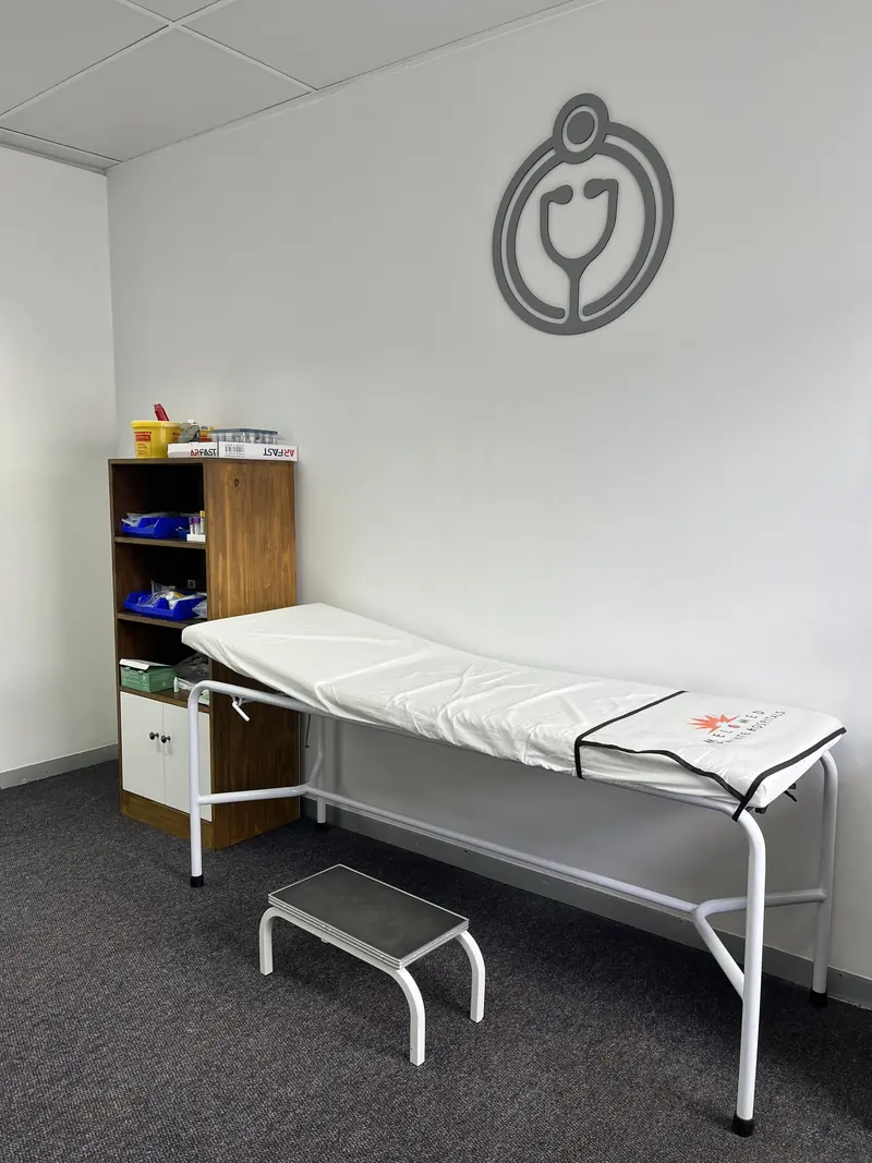 The examination room with a couch and the practice logo on the wall
