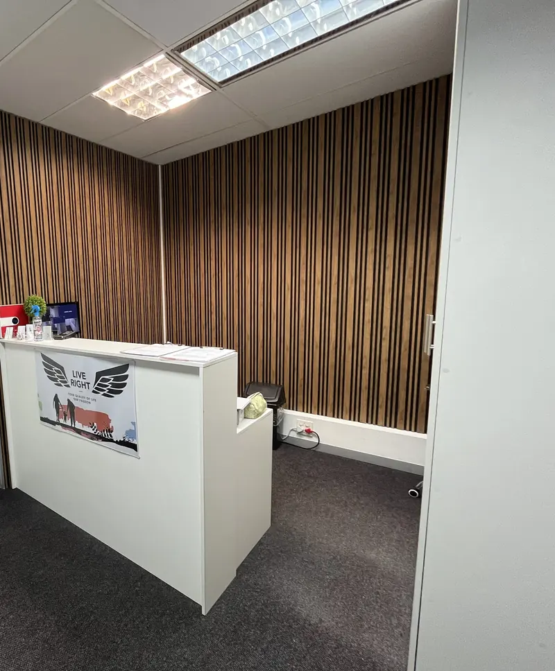 The reception desk in front of a timber slat wall